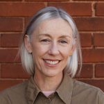 Dee Halligan Dee Halligan in front of a red brick wall